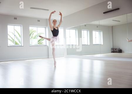 Kaukasische Balletttänzerin, die sich auf ihre Übung mit den Armen über ihrem Kopf konzentriert Stockfoto