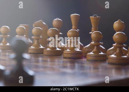 Schach auf einem Schachbrett, schwarze Bauern gegen eine Armee von Weiß Stockfoto
