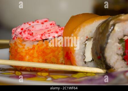 Sushi Brötchen mit Lachs, Aal, Frischkäse Philadelphia, Kaviar und tobica Futtersticks auf der Platte Stockfoto