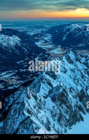 Tagesanbruch auf der Zugspitze Gipfel mit Blick auf Garmisch Partenkirchen und Loisach river valley beleuchtet Stockfoto