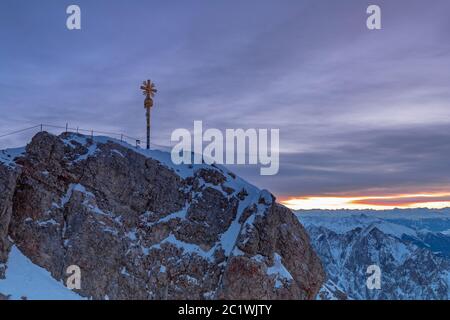 Tagesanbruch auf der Zugspitze Gipfel mit Gipfelkreuz Stockfoto