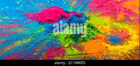 Abstrakt bunte Happy Holi Hintergrund. Farbe lebendiges Pulver auf Holz. Staubfarbene Spritzstruktur. Flach lagen holi Farbe decorati Stockfoto