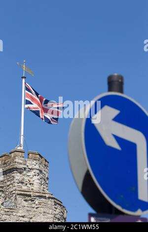 Britische Flagge Union Jack fliegt über Westgate Towers Canterbury Kent mit einem Schild links im Vordergrund Stockfoto