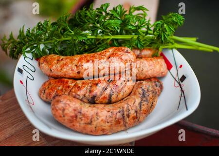 Gegrillte bayerische Würstchen auf einem weißen Teller. Stockfoto