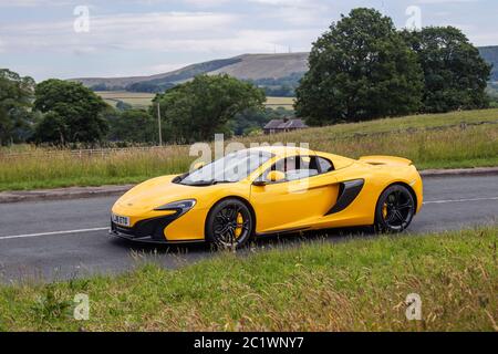 2016 gelber MCLAREN 675LT SPIDER; Fahrzeuge mit fahrendem Verkehr, Supersportwagen auf britischen Straßen Stockfoto