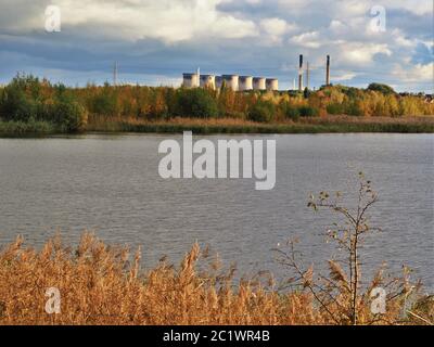 Blick über den Fluss Aire von Fairburn ings in West Yorkshire, England, mit den Türmen des Kraftstation Ferrybridge im Hintergrund Stockfoto