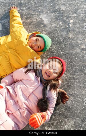 Die glücklichen Kinder spielen Eisbahn Stockfoto