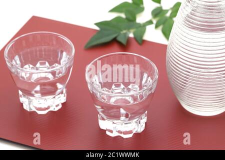 Japanischer Sake in transparentem Glas Tasse und Glas auf weißem Hintergrund Stockfoto