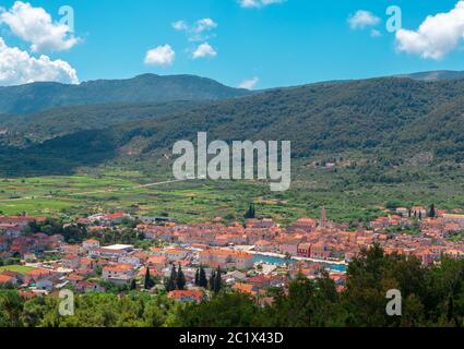 Malerisches Panorama der Stadt Starigrad auf der Insel Hvar. Von einem nahegelegenen Hügel aus gesehen. Alte Kirche Glockenturm erhebt sich über den Gebäuden, Stadt umgeben Stockfoto