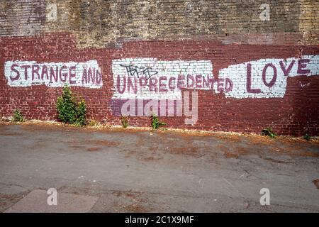 Brighton UK, 15. Juni 2020: Blick auf Brighton mit Street Art, die "Trange und beispiellose Liebe" erklärt Stockfoto