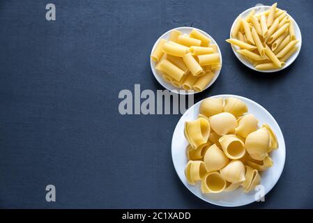 Verschiedene Arten von Pasta auf dem dunklen Hintergrund Stockfoto