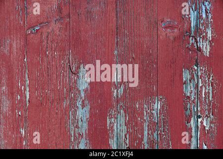 Eine kaputte Holzwand mit alter roter Farbe Stockfoto