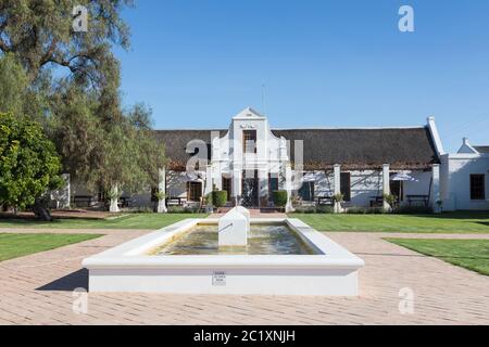 Bon Courage Winery, Robertson Wine Valley, Western Cape Winelands, Südafrika. Außenansicht des historischen kapholländischen Gehöfts und Brunnens aus dem Jahr 1818 Stockfoto