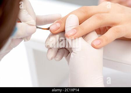 Nahaufnahme der Hand der Manikurist Anwendung klaren Nagellack im Schönheitssalon. Stockfoto