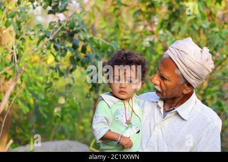 Ein kleines Kind und Großvater im Garten, Indien Stockfoto