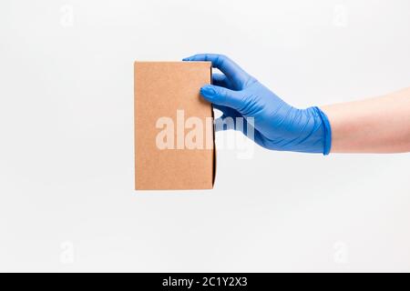 Pappkarton für Lebensmittel auf weißem Hintergrund in einer Handschuhen. Lebensmittelzustellung in biologisch abbaubaren Boxen. Stockfoto