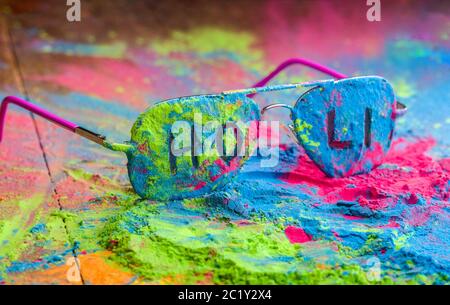 Holi Farbpulver auf Sonnenbrille. Organische Gulal Farben auf Brillen für Holi Festival, Hindu Tradition festlich Stockfoto