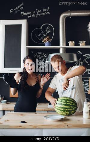 Schöner Mann schneiden Wassermelone und teilen es mit Frau. Stockfoto