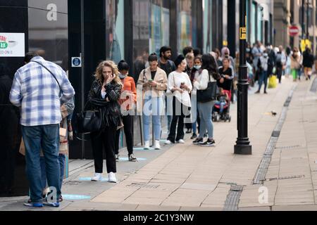 (200616) -- MANCHESTER, 16. Juni 2020 (Xinhua) -- vor einem Primark-Laden im Zentrum von Manchester, Großbritannien, 15. Juni 2020, stehen Menschen Schlange. Obwohl strenge zwei Meter-Entfernungsregeln fortfuhren, stellten sich die Kunden Schlange, um die Türen ihrer Lieblingsgeschäfte in England Montagmorgen zu betreten. Einwegsysteme rund um die Einkaufspassanlagen wurden ebenfalls eingeführt, wobei die Mitarbeiter sicherstellten, dass die Kunden die Regeln einhalten. (Foto von Jon Super/Xinhua) Stockfoto