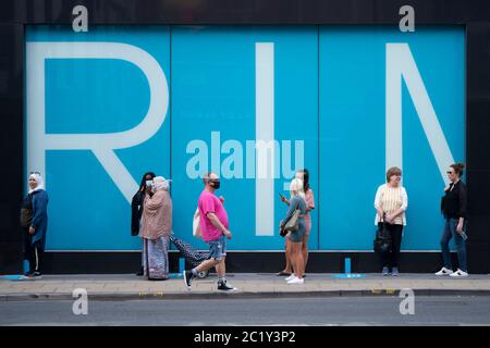 (200616) -- MANCHESTER, 16. Juni 2020 (Xinhua) -- vor einem Primark-Laden im Zentrum von Manchester, Großbritannien, 15. Juni 2020, stehen Menschen Schlange. Obwohl strenge zwei Meter-Entfernungsregeln fortfuhren, stellten sich die Kunden Schlange, um die Türen ihrer Lieblingsgeschäfte in England Montagmorgen zu betreten. Einwegsysteme rund um die Einkaufspassanlagen wurden ebenfalls eingeführt, wobei die Mitarbeiter sicherstellten, dass die Kunden die Regeln einhalten. (Foto von Jon Super/Xinhua) Stockfoto