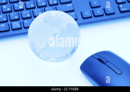 Glas Kugel Kugel mit Tastatur auf blauem Hintergrund Stockfoto