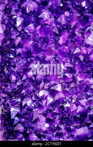 Amethyst purpurner Kristall. Mineralkristalle in der natürlichen Umgebung. Textur aus edlem und halbschädlicher Edelstein Stockfoto