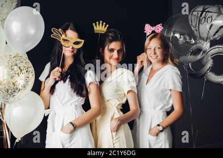 Brautjunfer tragen lustige Masken mit Braid posing Stockfoto