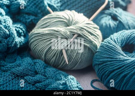 Kugeln aus farbigem Garn mit Stricknadeln aus nächster Nähe Stockfoto