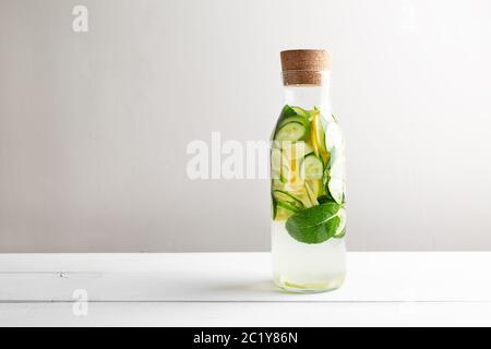 Freche Diät Wasser. Gurke, Zitrone, Minzlimonade in Gläsern auf weißem Holztisch. Stockfoto