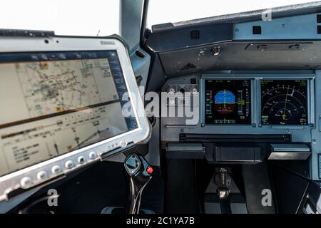 Airplane Cockpit, Captain Site mit der Primary Flight Display und Navigationsanzeige vorne und der Computer mit Navigationskarten direkt über dem Seitenstock Stockfoto