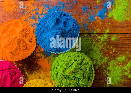 Ansicht von oben auf buntes traditionelles holi Pulver in Schalen auf Holz Stockfoto