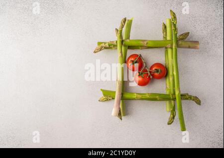 Frische Spargel Stiele in Form eines Brunnens in Kirschtomaten mit Kopieplatz. Das Essen war von oben aus zu sehen Stockfoto