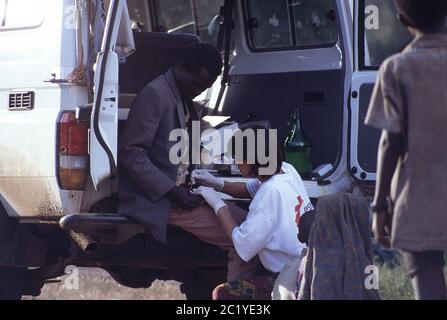 MSF Krankenschwester behandelt Tutsi Flüchtling aus dem Rücken von 4x4 auf der Ruanda Burundi Grenze 1994 Stockfoto