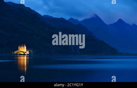 Ein Flutlicht Eilean Donan Castle und die fünf Schwestern von Kintail Stockfoto