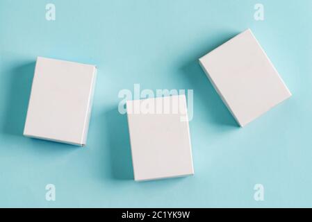 Set aus drei Papier-Mock-up-Boxen für Verpackungen von Produkten und Dingen auf einem pastellblauen Hintergrund. Stockfoto