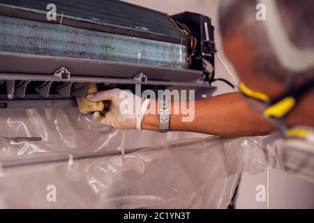 Mann Arbeiter tun professionelle Reinigung der Klimaanlage. Stockfoto