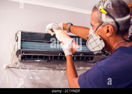 Mann Arbeiter tun professionelle Reinigung der Klimaanlage. Stockfoto