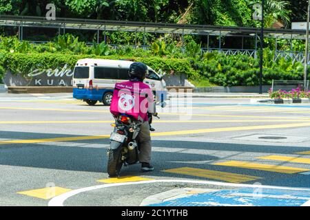 Kurier eines beliebten Lebensmittel-Lieferservice in Malaysia auf einem Fahrrad. Essen bestellen zu Hause. Stockfoto