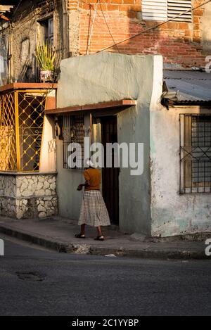 Frau, die in einer Straße in einem Wohnviertel, Santiago de Cuba, Kuba, vorbeikommt Stockfoto