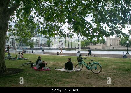 LONDON, GROSSBRITANNIEN. 16. Juni 2020. Menschen auf London Riverside sitzen, während sich dunkle Regenwolken mit einer prognostizierten Niederschlagsmenge zu bewegen beginnen. Kredit: amer ghazzal/Alamy Live Nachrichten Stockfoto