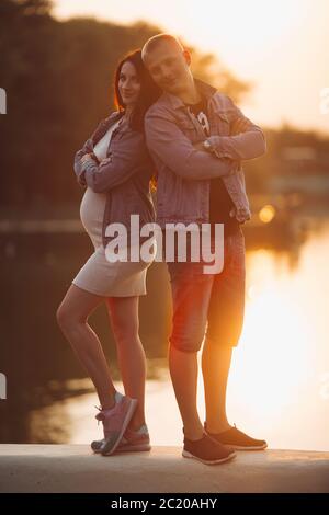 Schöne Eltern stehen in der Nähe von See und zusammen Posieren Stockfoto