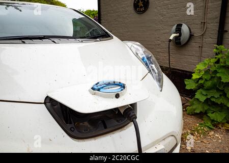 Nissan Leaf Elektroauto und Wohngebäude Ladestation Stockfoto