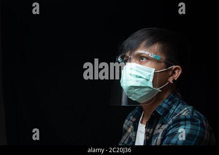 Nahaufnahme Portrait Mann Tragen Sie einen Gesichtsschutz und Maske für Ausbruch Coronavirus oder Covid-19, New Normal Concept Stockfoto