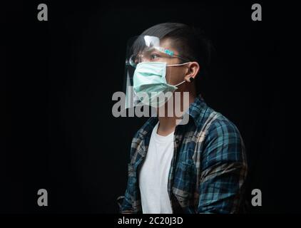 Hoffnungsvoller Mann trägt einen Gesichtsschutz und Maske für Ausbruch Coronavirus oder Covid-19, New Normal Konzept Stockfoto