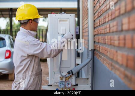 Der Klimatechniker überprüft den Luftkompressor. Stockfoto