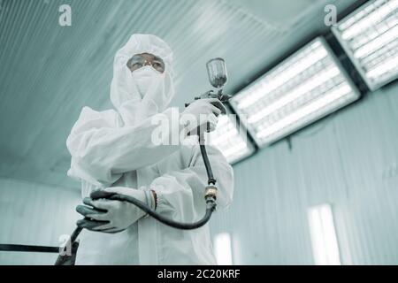 Airbrush Sprühen Farbe Mann tragen Tuch und Maske Uniform bereit arbeiten in der Farbe Malerei Garage Stockfoto