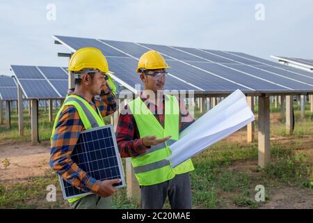 Das Engineering-Team prüft die Pläne für die Befestigung oder Reparatur von Solarmodulen und anderen Analysen. Stockfoto