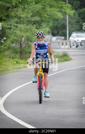 Ein attraktiver junger Radfahrer, wahrscheinlich Koreanisch-Amerikaner, fährt auf einem Pfad nahe dem Cross Island Parkway in Bayside, Queens, NYC. Stockfoto