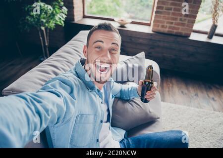 Nahaufnahme Foto von häuslichen gutaussehend Kerl zu Hause bleiben Quarantäne Zeit machen Selfies für Blog erzählen Anhänger, was er tun selbst Isolation Bier trinken Stockfoto