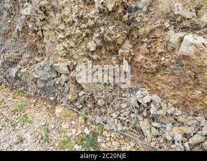 Robustes Metallschutznetz in den Bergen, um zu verhindern, dass Steine auf der Straße fallen Stockfoto